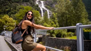 Une femme latine souriante visitant une belle cascade
