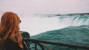 Femme aux cheveux rouges debout près des chutes du Niagara