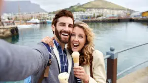 couple mangeant une glace prenant un selfie en vacances